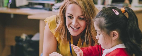 Smiling primary school teacher with a pupil