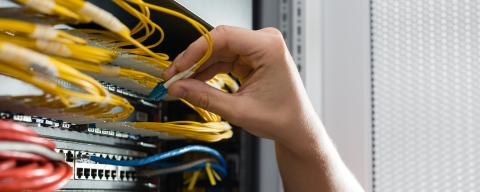 hand altering wires on an electrical board