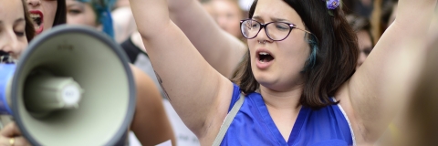 Female protester raising her arms during a march