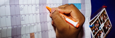 Person writing on calendar 