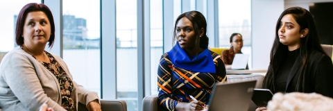Group of people sitting at a desk with law documents and wig