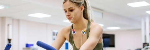 Person on an exercise bike monitored by an ECG