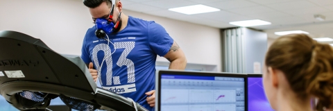 Person exercising on a treadmill while their breathing is monitored