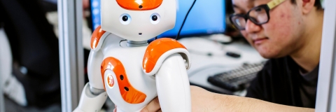 Robot being fixed by computer engineer