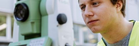 Student conducts measurements using landscape mapping device outside Technology Facilities