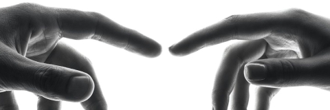 two hands reaching to touch each other 