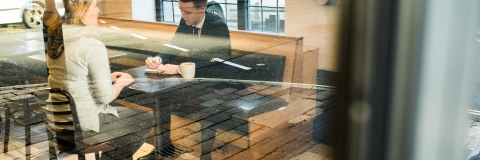 two people sitting at a table looking at notes