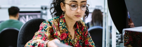 Female University of Portsmouth student feeding paper into a printer