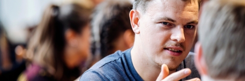 Young man in conversation with older man