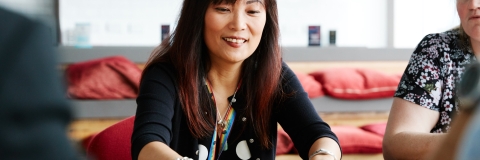 Female researcher demonstrating to team members at table