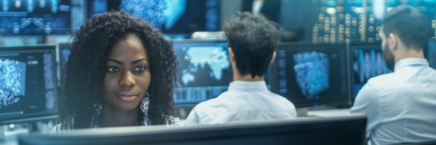 Female cyber security worker working at computer