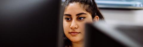 a female student from lebanon working at a computer 