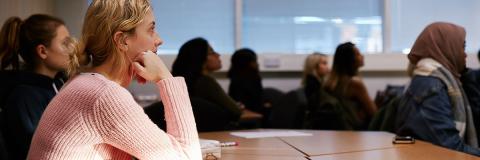 A female student in a seminar with other students.