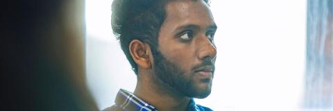 A male student from Nepal with folded arms