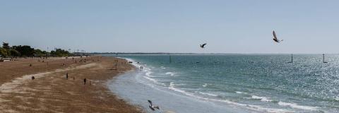 Figures walking on beach on the Portsmouth seafront