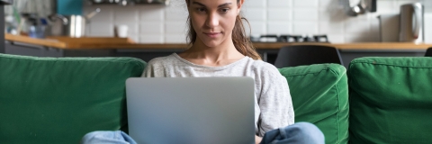 Female student relaxed at home with book