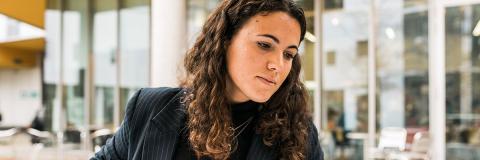 female student from Spain in business wear browsing a folder