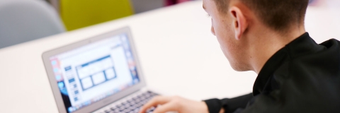 student in library using laptop