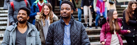 Two male international students walking down steps with others behind them