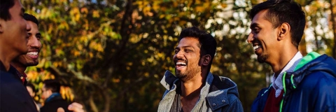 Four Indian students smiling and laughing while in conversation