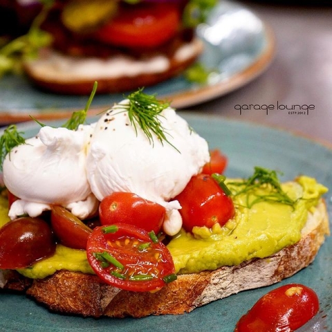 Smashed avocado on toast with cherry tomatoes and mascarpone