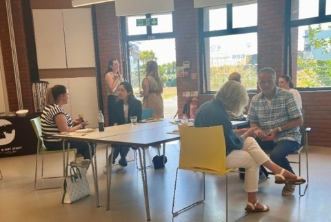 Students in a room at tables talking