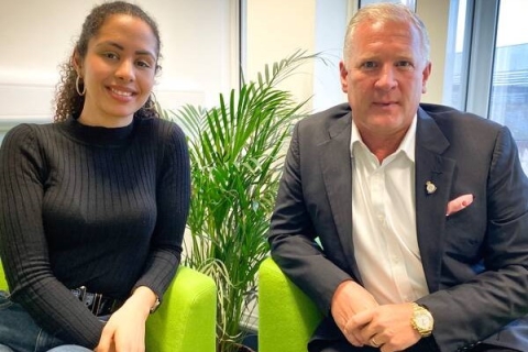 Student and entrepreneur Mark Smith sitting in green chairs. 