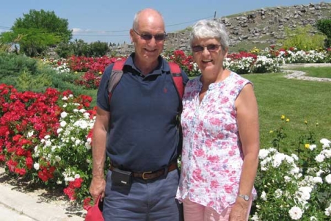 Erich and Trisha smiling to camera wearing sunglasses surrounded by flowers and grass
