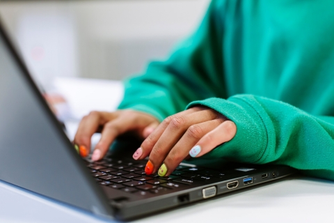 Hands typing on laptop
