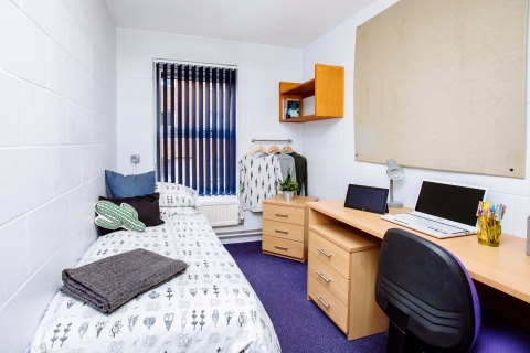A bedroom in Bateson student halls with a bed, desk, and chair