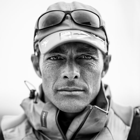 Hugh Styles headshot wearing cap and waterproof jacket staring to camera in black and white image