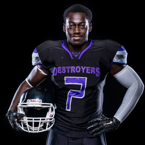 Picture of Jason Selormey wearing UoP kit holding american football helmet in one hand with his other hand on his hip