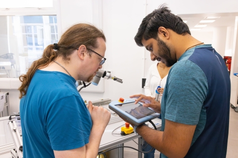 Postgraduate research students experimenting with robotics lab equipment
