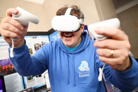 Man in blue hoodie using medical technology device.