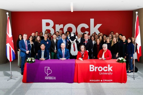 People gather for a group photo during the Brock University and University of Portsmouth signing