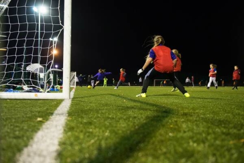 A football match on a pitch at night