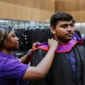 graduate putting on gown