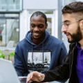 two male students talking and smiling