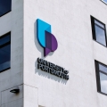 University of Portsmouth logo on white brick building
