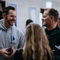 A member of University of Portsmouth staff smiling with some parents at an Open Day