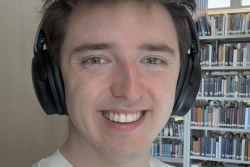 Student smiling and wearing headphones.
