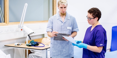 Male and female nursing students take notes