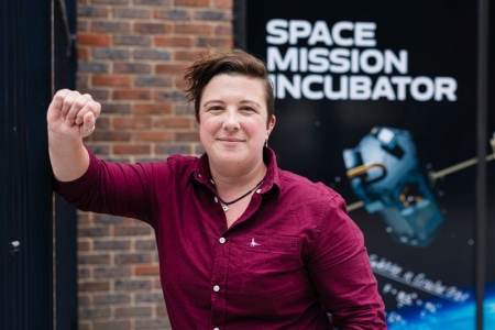 Dr Lucinda King standing in front of the sign for the Space Mission Incubator service
