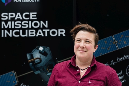 Dr Lucinda King standing in front of the sign for the Space Mission Incubator service