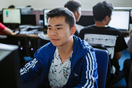 Male student working on computer in computer lab