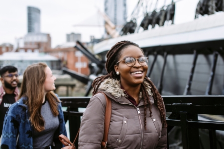 Female student smiling while passing by harbour