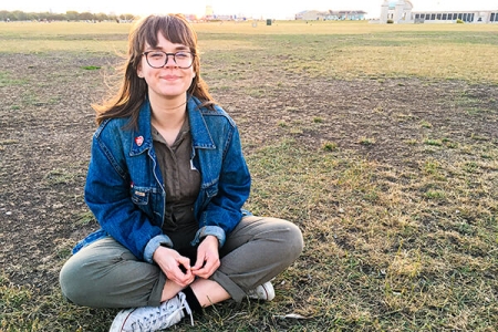 Woman sitting cross legged smiling at camera