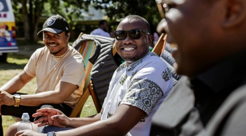 Students smiling and sitting on deck chairs