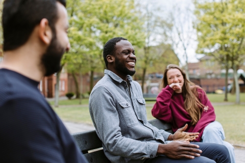 Three students sat on bench relaxing